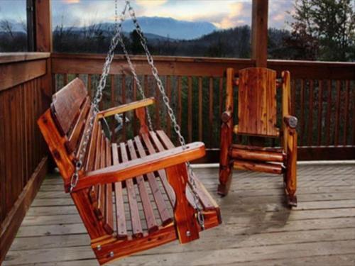 two wooden rocking chairs sitting on a porch at Spacious Party Hut Near Attractions in McCookville