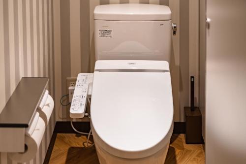 a bathroom with a white toilet in a room at I-Link Hostel & Cafe Shimanami in Imabari