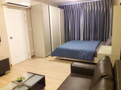 a bedroom with a bed and a couch in a room at Plum Phahol89, Prachathipat in Ban Talat Rangsit