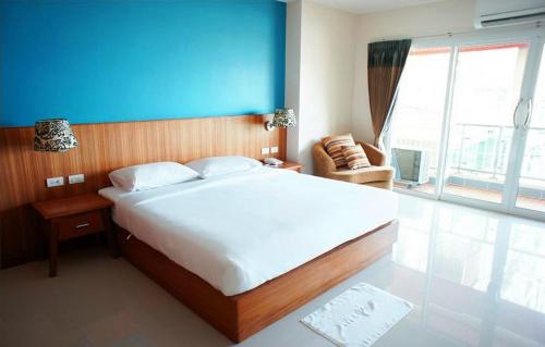 a bedroom with a large bed with a blue wall at D Apartment in Pattaya