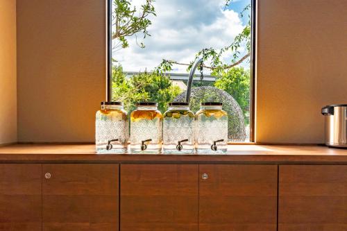 a group of four bottles of honey sitting on a counter at I-Link Hostel & Cafe Shimanami in Imabari
