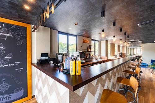 a bar in a restaurant with a counter and chairs at I-Link Hostel & Cafe Shimanami in Imabari
