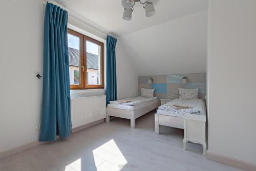 a small room with two beds and a window at Malinowe Wzgórze domki 90 m2 z sauną i balią in Krzeszna