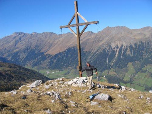 a man standing next to a cross on a mountain at Hotel Bergblick in Racines