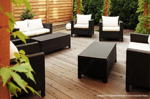 a group of wicker chairs and tables on a patio at Best Western Macrander Hotel Dresden in Dresden