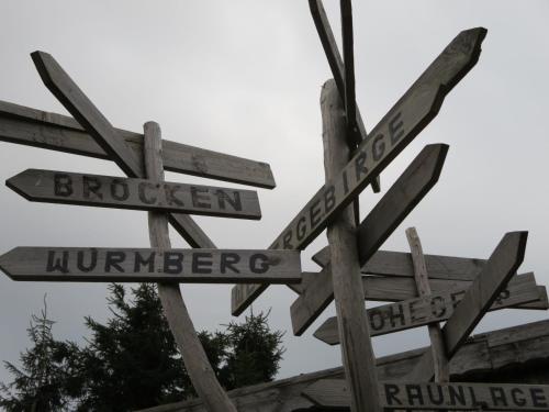 a street sign with arrows pointing in different directions at HARZ HOTEL und Gästehaus am Bornweg in Bad Sachsa