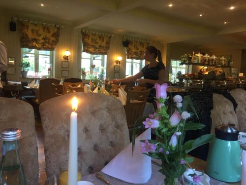 a woman sitting at a table in a restaurant at Haus Honigstal Landhaus Café in Wuppertal