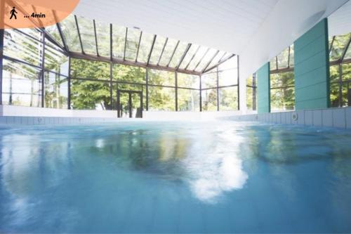uma grande piscina com água azul num edifício em Le Baron em Évian-les-Bains