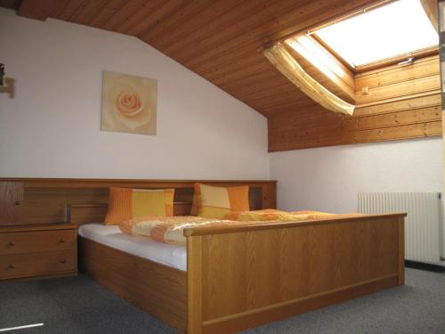 a bedroom with a large wooden bed with a skylight at sHoamatl in Pfunds
