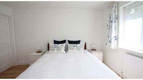 ein weißes Schlafzimmer mit einem großen weißen Bett mit Kissen in der Unterkunft ★ Luxury Oxford Apartment ★ Sleeps 4, Free Parking in Oxford