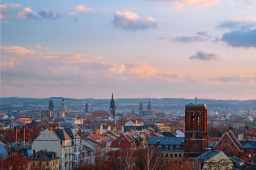 a view of a city at sunset with buildings at Best Western Macrander Hotel Dresden in Dresden
