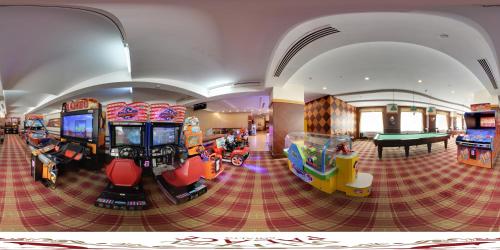 een kamer met verschillende arcadespellen en een pooltafel bij Delphin Palace Hotel in Lara