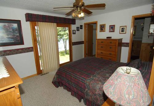 1 dormitorio con 1 cama y ventilador de techo en Ranch-Style Seidls Home en Namekagon