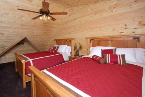 1 Schlafzimmer mit 2 Betten in einem Blockhaus in der Unterkunft A Suite Mountain Retreat Cabin in Pigeon Forge