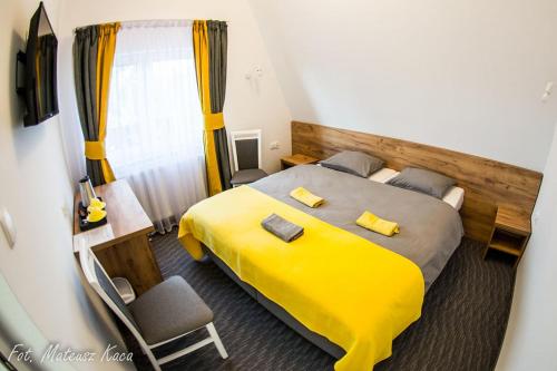 sypialnia z dużym łóżkiem z żółtą pościelą w obiekcie Karmuszka Family House z jacuzzie, sauną i siłownią na wyłączność w mieście Łukta