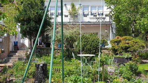 a garden with a swing in front of a house at Les Iris Chambres d’hôte in Niedermorschwihr