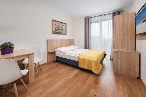 1 dormitorio con cama, escritorio y mesa en Willa Daniela - Chłapowo en Władysławowo