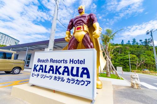 a statue of a superhero standing next to a sign at Beach Resort Hotel Kalakaua in Onna