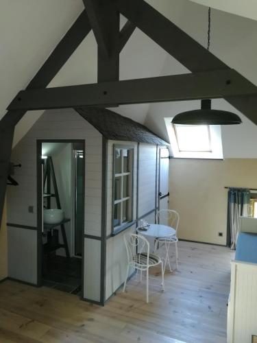 une pièce avec une table, des chaises et un plafond dans l'établissement Les longères de keridy, à Brech