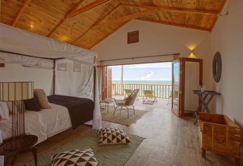 a bedroom with a bed and a view of the ocean at Asali Beach House in Jambiani