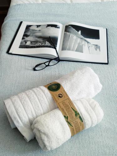 a book and a pair of towels on a bed at Hostal Sa Posada Set Cales in Ciutadella