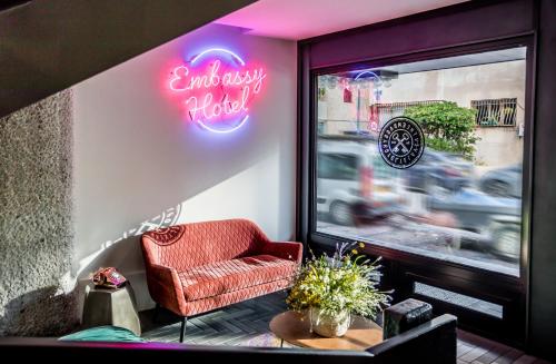 a room with a chair and a sign on a window at Embassy Hotel Tel Aviv in Tel Aviv