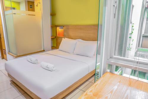 1 dormitorio con 1 cama con 2 toallas en LeGreen Suite Poso, en Yakarta