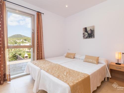 a bedroom with a bed and a large window at Vaumera f in Sa Pobla