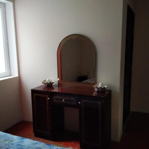a bedroom with a dresser with a mirror on it at Goga Guesthouse in Sighnaghi