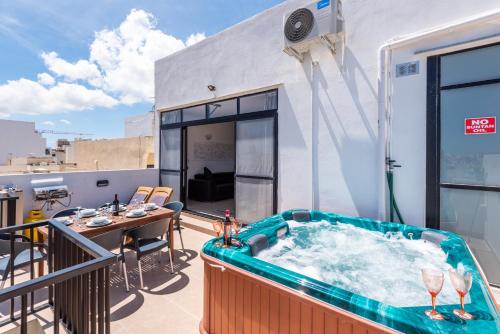 - Balcón con mesa y bañera de hidromasaje en Seashells Sea View Penthouse with private Hot Tub & large sunny terrace with stunning views - by Getwaysmalta en St. Paul's Bay