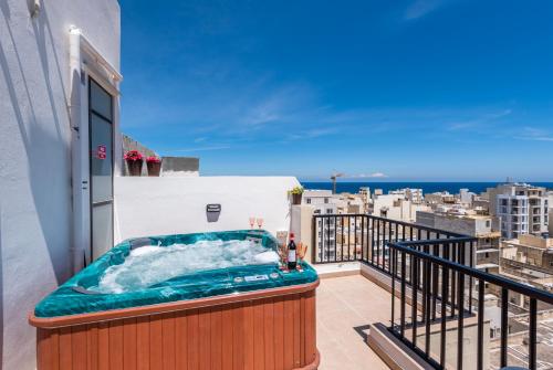 bañera de hidromasaje en el balcón de un edificio en Seashells Sea View Penthouse with private Hot Tub & large sunny terrace with stunning views - by Getwaysmalta en St. Paul's Bay