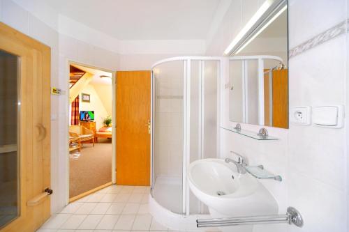 ein Bad mit einem Waschbecken und einer Dusche in der Unterkunft Pension Villa Stella in Špindlerův Mlýn