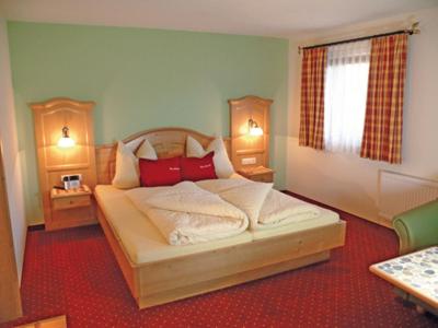 タンハイムにあるPension Obermühleのベッドルーム(赤い枕の大きな白いベッド付)