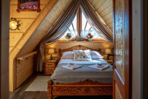 a bedroom with a bed in a attic at Góralska Zagroda in Dzianisz