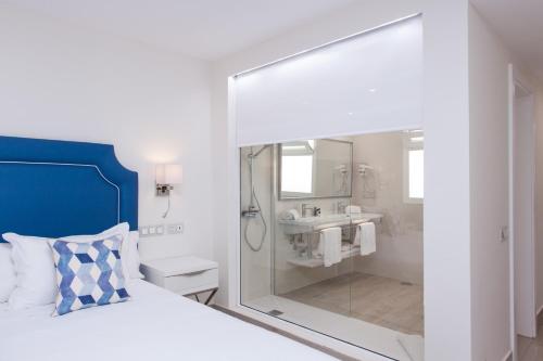 a bathroom with a bed and a shower and a sink at Hotel Boutique TAO Caleta Mar in Corralejo