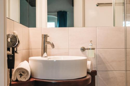 a bathroom with a sink and a mirror at Inselresort Wilhelmstein in Steinhude