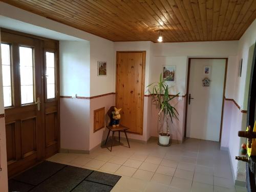 a hallway with a wooden ceiling and a door at La Maison Jaune in Ammerschwihr