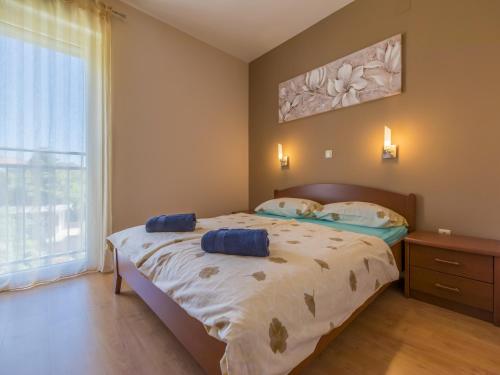 ein Schlafzimmer mit einem Bett mit zwei blauen Kissen darauf in der Unterkunft BRUNO in Crikvenica