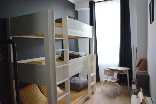 Etagenbett in einem Zimmer mit einem Schreibtisch in der Unterkunft Le Central Wimereux in Wimereux