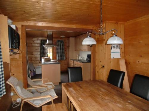 jadalnia z drewnianym stołem i krzesłami w obiekcie Chalet Valaisia w mieście Riederalp