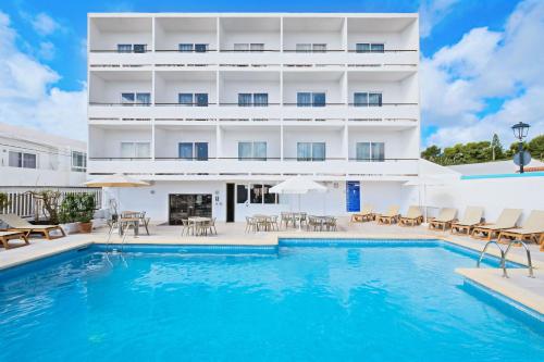 une piscine en face d'un bâtiment avec un hôtel dans l'établissement azuLine Hotel Mediterráneo, à Santa Eulària des Riu