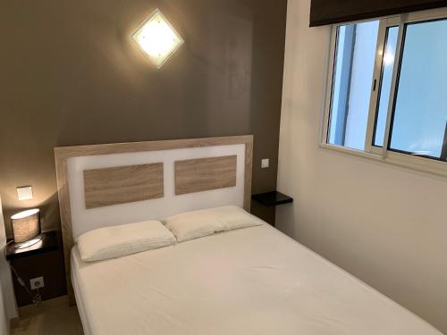 a white bed in a room with a window at AwayDays - 94 - Appartement 1 Chambre Vue Mer in Empuriabrava