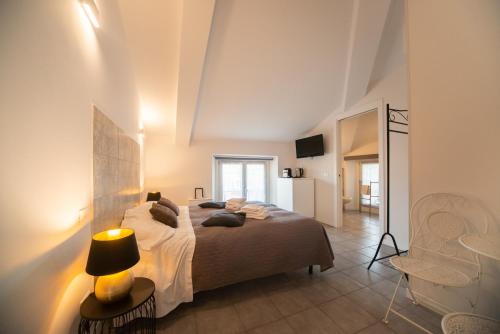ヴェローナにあるCasa Ferrovieriのベッドルーム1室(ランプと椅子付きのベッド1台付)