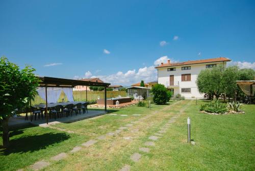 a garden with tables and a building in the background at Dolce Sosta in Lucca