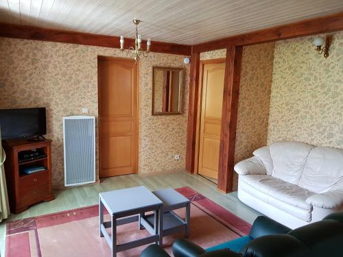 a living room with a couch and a tv at La Maison Jaune in Ammerschwihr