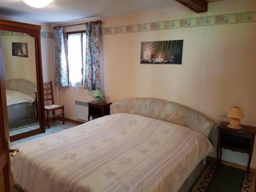 a small bedroom with a bed and a mirror at La Maison Jaune in Ammerschwihr