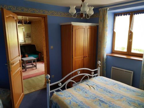a blue bedroom with a bed and a mirror at La Maison Jaune in Ammerschwihr