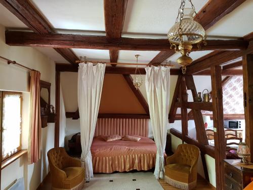 1 dormitorio con 1 cama y 2 sillas en La Maison Jaune en Ammerschwihr