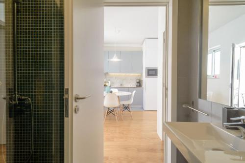 een badkamer met een douche en een wastafel en een keuken bij LAZ apartment in Porto