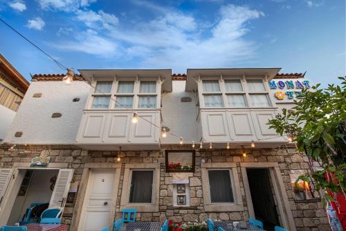 a building with white windows and lights on it at Monat Otel Alaçatı in Alaçatı